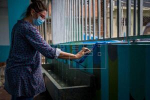 Una mujer abre las llaves de una tubería por donde sale agua filtrada de lluvia en una escuela, en Caracas (Venezuela)., en una fotografía de archivo. EFE/ Miguel Gutiérrez